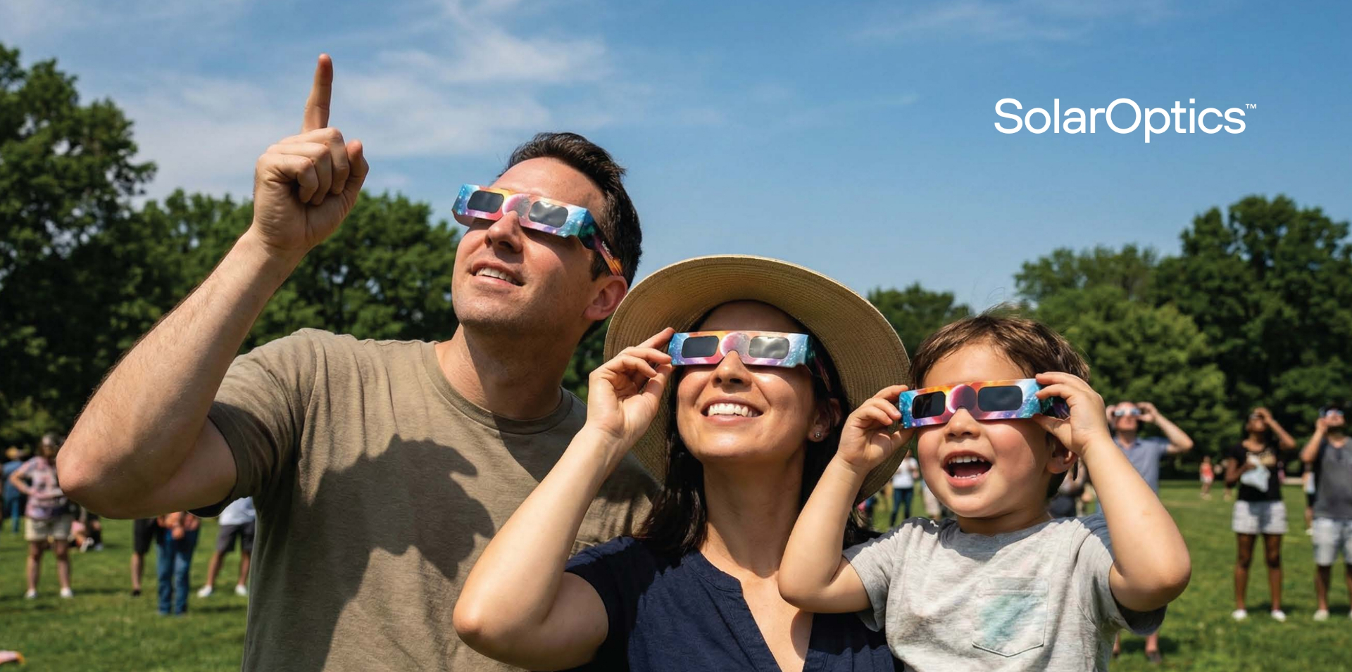 Family wearing certified eclipse glasses looking up at the solar eclipse